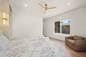 A bedroom with a bed, a ceiling fan, a window, and a view of the outside. - High View: Brand-New 5,100 Sq Ft Nordic-Inspired Mountain Estate with Four-State Views (Banner Elk)