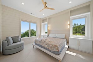 A bedroom with a bed, a sofa, a ceiling fan, and large windows. - High View: Brand-New 5,100 Sq Ft Nordic-Inspired Mountain Estate with Four-State Views (Banner Elk)