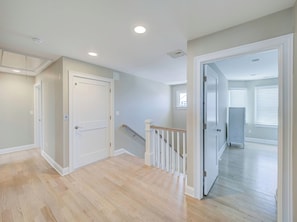 A spacious hallway with a wooden floor, white doors, and a staircase with a handrail. - Family friendly Lagoon front 2 blocks to ocean.
8 Beach Badge. 
3 TV Beach Chair (Lavallette)
