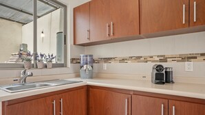 A kitchen with wooden cabinets, a stainless steel sink, a water dispenser, and a coffee maker. - Casa Mamino Pool Palapa & Pet Friendly (Cuernavaca)