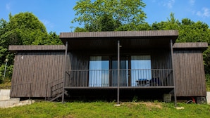 En moderne bygning i to etager med en balkon og en trappe op til øvre plan.