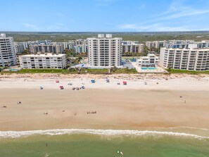 A coastal residential area with high-rise buildings, a sandy beach, and a clear sky. - Seascape Towers 621 (New Smyrna Beach)