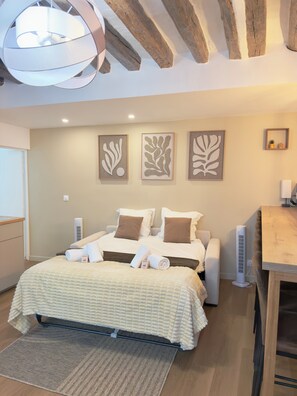A bedroom with a bed, bedside tables, a desk, and a ceiling light fixture. - Luxury Stay I Designer Duplex near Bastille (Paris)