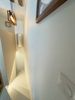 Eine moderne Treppe, eine Wandleuchte und ein gerahmtes Bild.