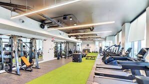 A gym with treadmills, weight machines, and a green carpeted area. - Cielo | Downtown Miami Condo,33 FL,  Rooftop Pool, Gym (Miami)