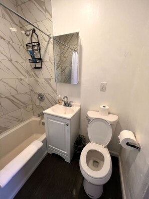 Ein Badezimmer mit Badewanne, Waschbecken, Toilette und Duschbereich.