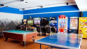 Ein Freizeitraum mit Billardtisch, Tischtennisplatte und Spielautomaten.