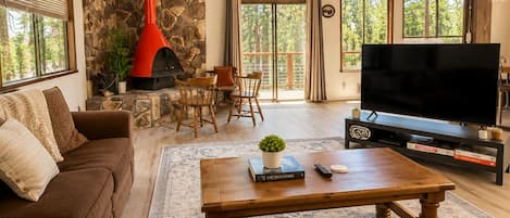 A spacious living room with a stone fireplace, a large flat-screen TV, and a cozy seating area.