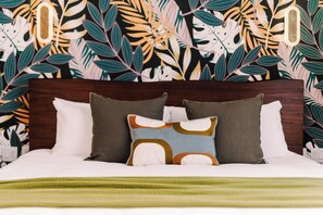 A bed with a wooden headboard, white bedding, and multiple pillows. - Lakay Monteverde (Monteverde)