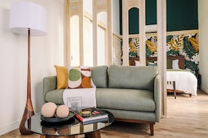 Un salon moderne avec un canapé vert, une table basse ronde et une lampe.