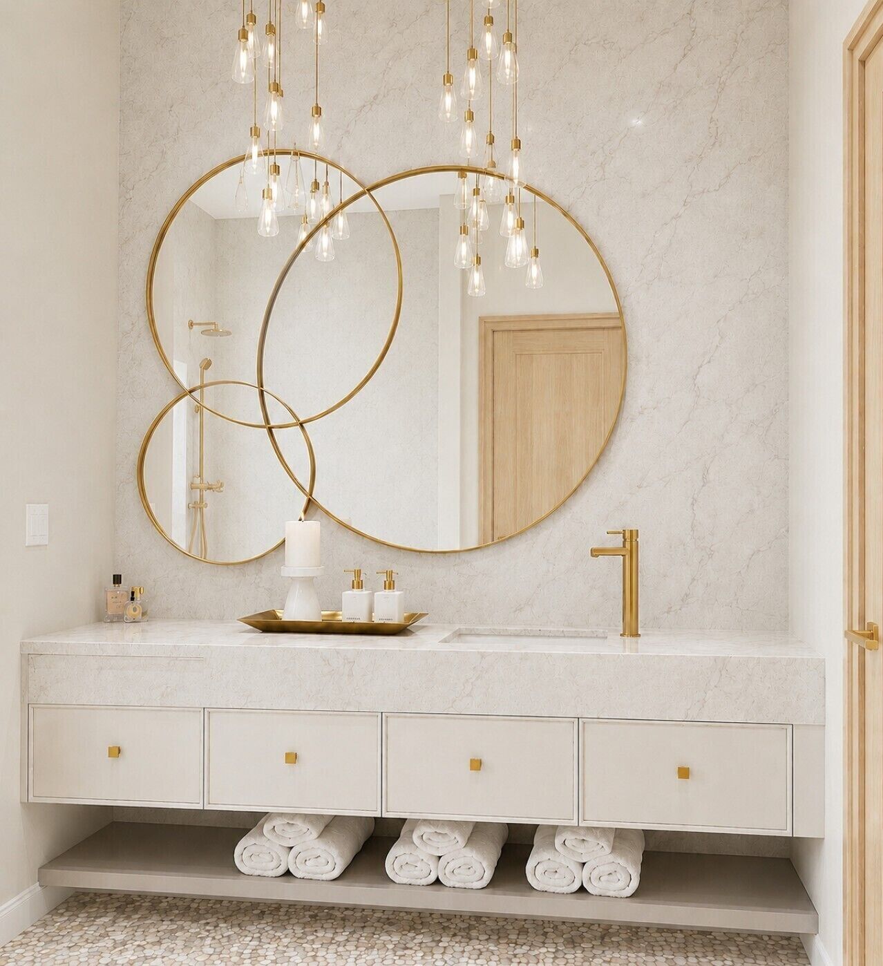 A bathroom with a marble countertop, gold fixtures, and a large mirror with circular frames.