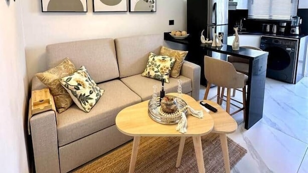 Uma sala de estar moderna com sofá, mesa de centro e obras de arte na parede.