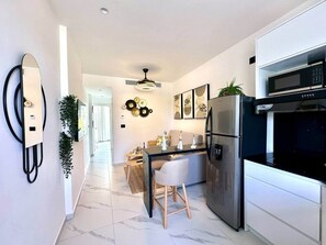 Eine moderne Küche mit Kühlschrank, Mikrowelle und Essbereich mit Tisch und Stühlen.