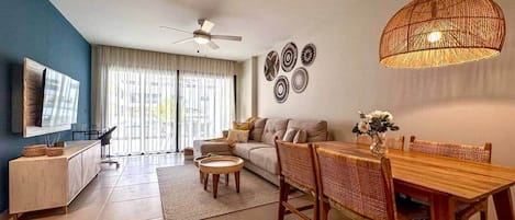 A living room with a sofa, a dining table, and a television.