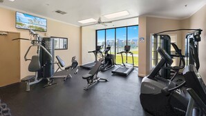 Ein Fitnessstudio mit Cardiogeräten, Kraftmaschinen und einem großen Fenster mit Blick.