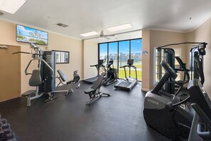 Ein Fitnessstudio mit Cardiogeräten, Kraftmaschinen und einem großen Fenster mit Blick.