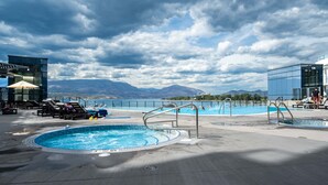 Ein Pool auf dem Dach mit Liegestühlen, einem Whirlpool und Blick auf die Berge.