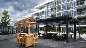 Ein modernes Gebäude mit überdachter Außenbereich-Sitzgelegenheit und einer Holz-Spielanlage.