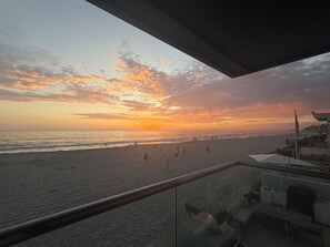 A beach view from a balcony with a railing, a clear sky, and the ocean. - Fabulous 2-bedroom oceanfront estate with AC in sunny Del Mar (Del Mar)