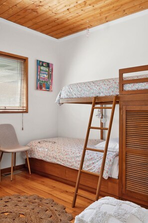 A bunk bed with a ladder, a chair, and a poster on the wall. - Beachside Nostalgia | Family Holiday Home on Dare Street, Pet friendly, Walk to the beach (Ocean Grove)