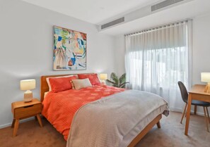 A bedroom with a bed, bedside tables, a desk, and a chair. - Driftwood – Luxury Coastal Townhouse in the Heart of Ocean Grove (Ocean Grove)