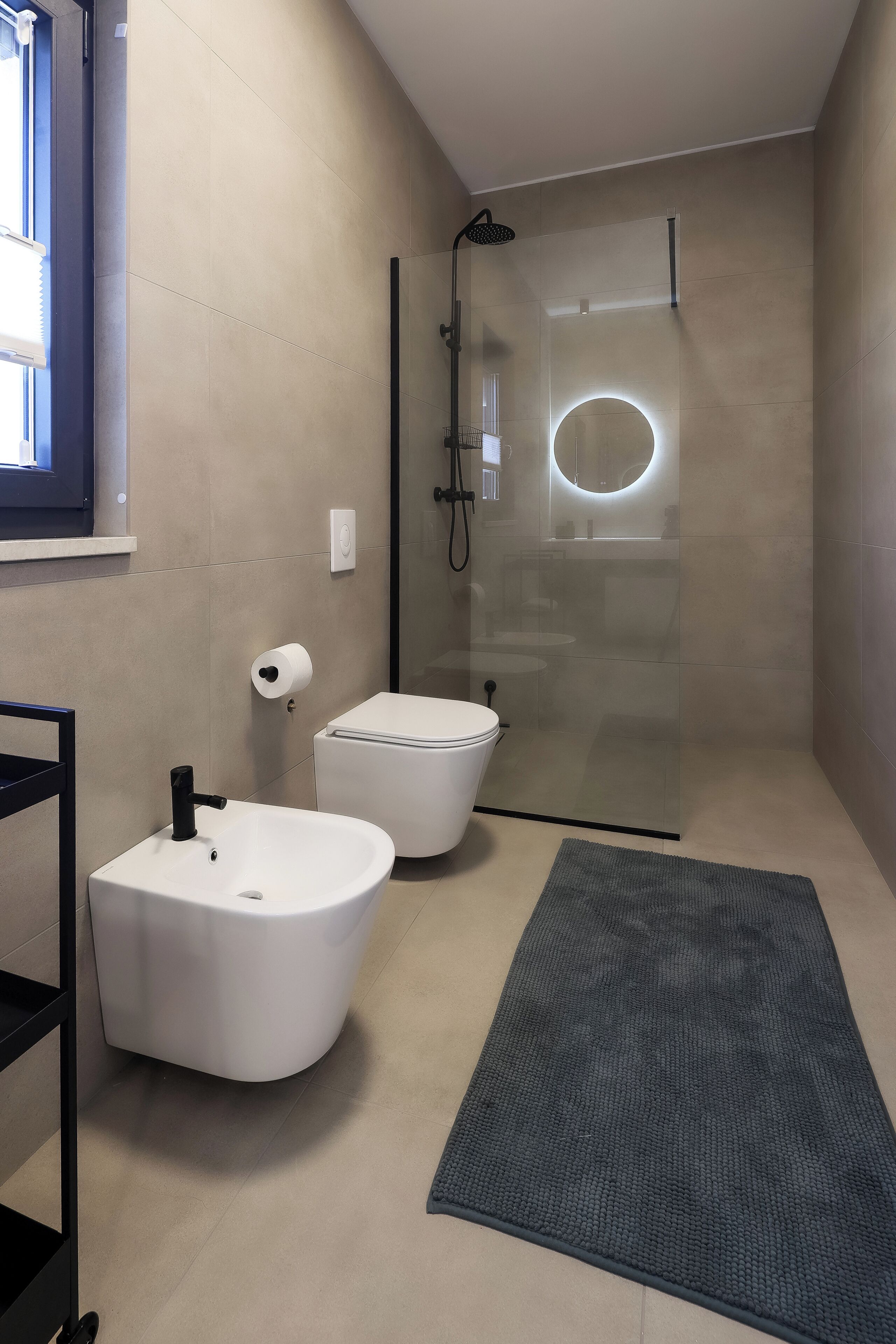 A modern bathroom with a glass-enclosed shower, a freestanding bathtub, and a toilet.
