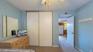 A bedroom with a bed, a dresser, a mirror, and a closet. - Starfish Haven|Lake View|Pool| Boat Ramp| Sleeps6 (Lake Ozark)