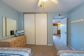 Ein Schlafzimmer mit Bett, Kommode, Spiegel und Schrank.