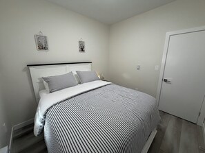 Ein Schlafzimmer mit einem Bett, einem Nachttisch und einer Tür.