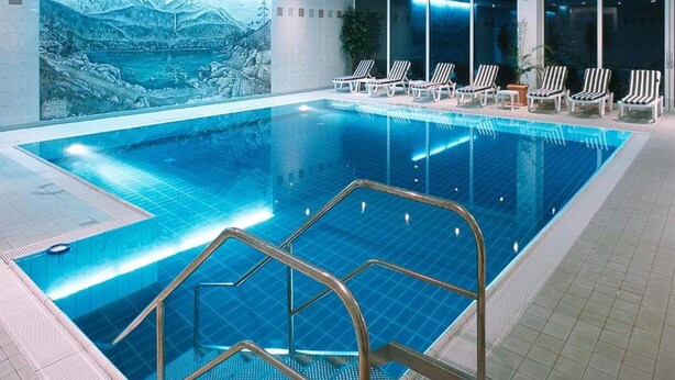 An indoor swimming pool with a view of a mountainous landscape, lounge chairs, and a tiled floor. - 2 Person Holiday Park Home in Garmisch-partenkirchen (Garmisch-Partenkirchen)