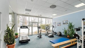 A gym with treadmills, elliptical machines, a bench, and weight equipment. - 2 Person Holiday Park Home in Garmisch-partenkirchen (Garmisch-Partenkirchen)