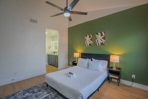 A bedroom with a bed, two bedside lamps, a ceiling fan, and artwork on the wall. - N Scottsdale Oasis Pool Balcony Parking WD WiFi (Scottsdale)