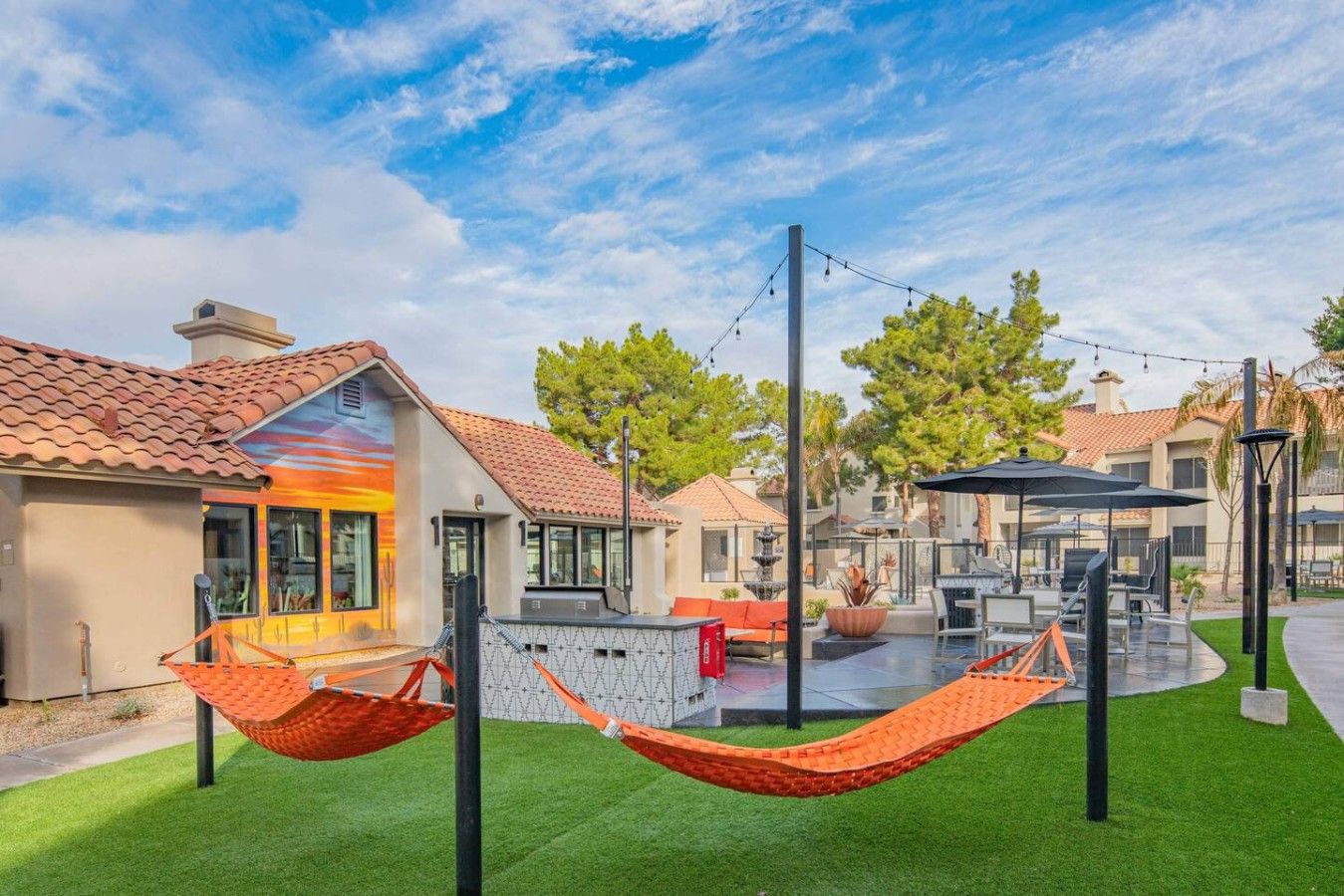 A residential area with houses, outdoor seating, and a hammock.