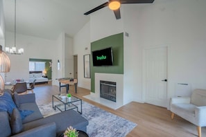 Een moderne woonkamer met een bank, salontafel en een open haard.