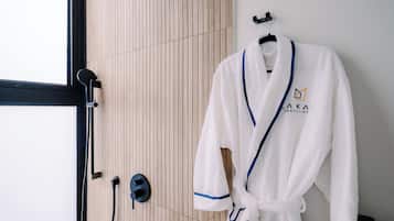 A white bathrobe with a blue trim and logo hanging on a hook.