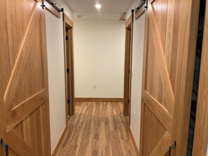 A hallway with wooden doors and a wooden floor.