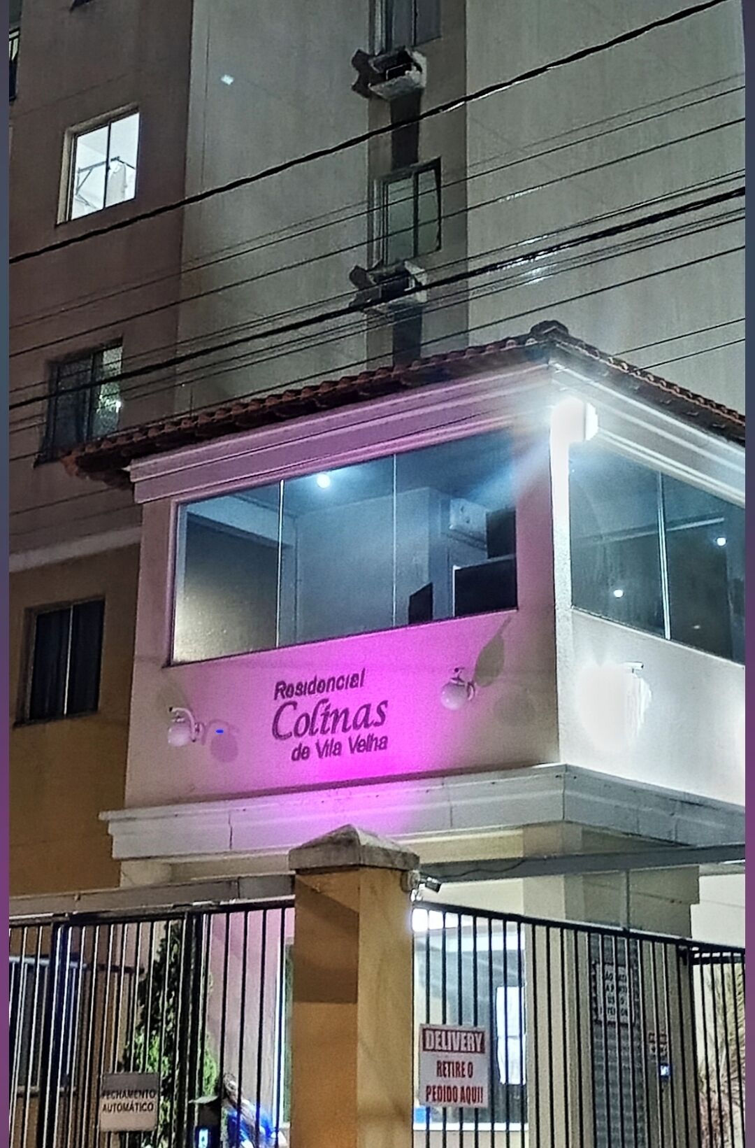 Un hôtel appelé « Colinas de Vila Velha », doté d’un balcon et d’une enseigne indiquant « Livraison » et « Ouverture automatique de la porte ».
