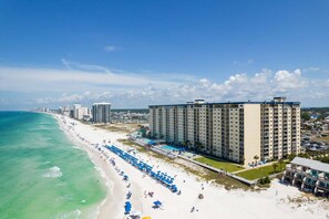 A coastal hotel with a beach view, multiple floors, and a pool area. - Fall Deals + Snowbird Rates | Gulf Front Beach Escape (Panama City)
