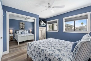 A bedroom with a bed, a dresser, a nightstand, a ceiling fan, and a window with a view. - Fall Deals + Snowbird Rates | Coastal Stay With Water Views (Palm Coast)