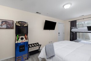Ein Hotelzimmer mit Etagenbett, einem an der Wand befestigten Fernseher, einer Krabschmaschine und einer Tür.