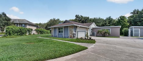 A residential area with houses, a driveway, and a well-maintained lawn.