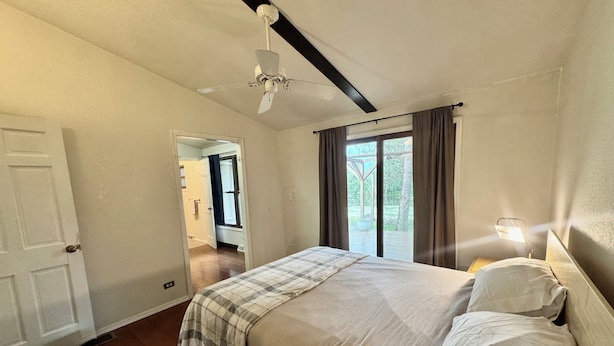 A bedroom with a bed, a ceiling fan, a window with curtains, and a door. - The Channel House on Lake Winneconne- 3 bedroom 2 bath with boat house game room (Winneconne)
