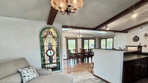 A spacious living area with a sofa, a dining table, and a kitchen island. - The Channel House on Lake Winneconne- 3 bedroom 2 bath with boat house game room (Winneconne)