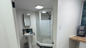A modern bathroom with a shower, sink, and mirror. - 1 bdrm apt. Sleeps 4. Pet friendly. Pasadena. (Between Corner Brook & Deer Lake) (Pasadena)