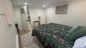 A bedroom with a bed, a dresser, a painting on the wall, and a door leading to another room. - 1 bdrm apt. Sleeps 4. Pet friendly. Pasadena. (Between Corner Brook & Deer Lake) (Pasadena)