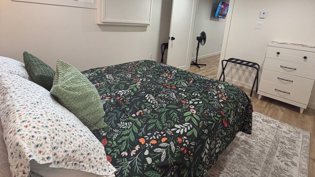 A bedroom with a bed, a dresser, a chair, a television, and a window. - 1 bdrm apt. Sleeps 4. Pet friendly. Pasadena. (Between Corner Brook & Deer Lake) (Pasadena)