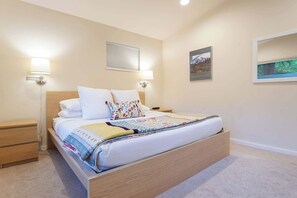 A bedroom with a bed, bedside tables, wall-mounted lamps, and framed pictures. - Fernwood Cabin | Private Hot Tub + Wood-Burning Fire Near Mt Baker (Deming)