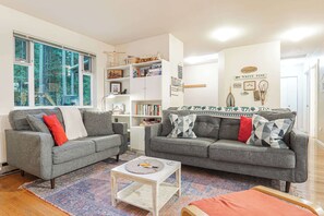 A living room with two grey sofas, a coffee table, and a bookshelf. - Mt Baker Forest Cabin Hot Tub Fireplace (Deming)