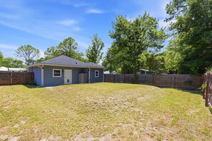 A residential property with a fenced yard, a single-story house, and a wooden deck. - Among the Palms Cottage - Close to Downtown (St. Augustine)
