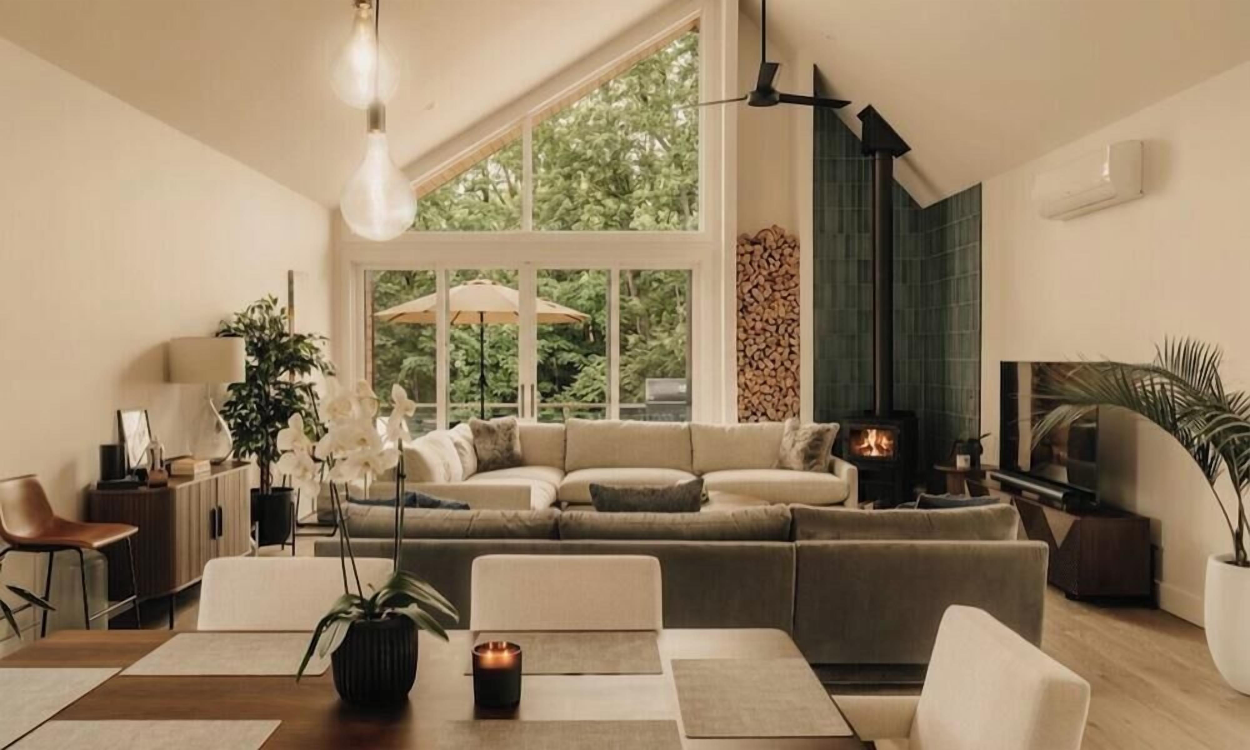 Uma sala de estar moderna com uma grande janela, lareira e um sofá.